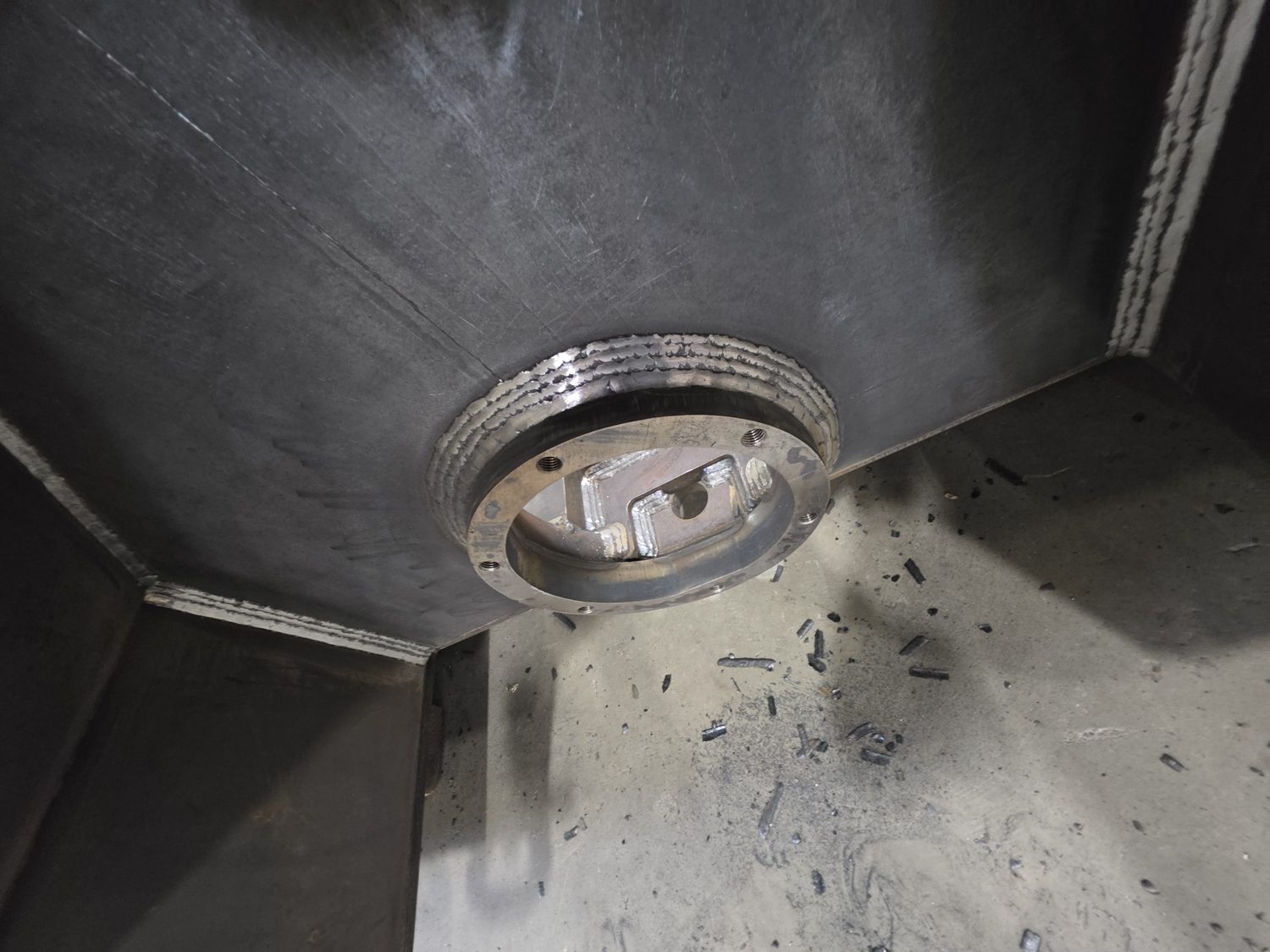 Fabricated steel hopper interior with machined mounting flange